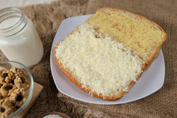 Bread with cheese, sweetened condensed milk, and butter. With white milk and snack on a table for breakfast	
