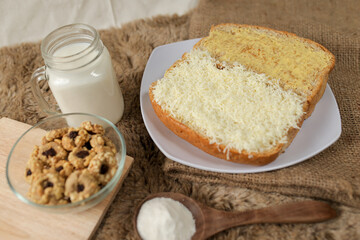 Bread with cheese, sweetened condensed milk, and butter. With white milk and snack on a table for breakfast	
