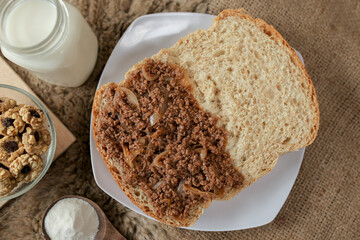 Bread with minced beef and union on a table. With white milk and snack for breakfast	
