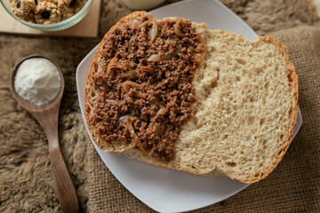 Bread with minced beef and union on a table. With white milk and snack for breakfast	
