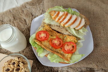 Big breakfast, bread, chicken slice, tomato, lettuce, smoked beef, egg, salad with milk. Bread sandwich fresh and healthy food meal lunch dinner breakfast slices of sandwiches.