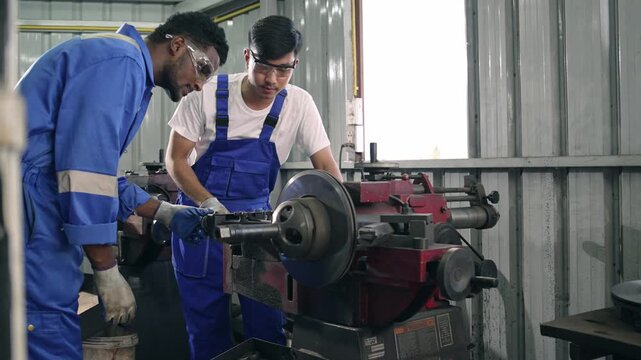 Diversity mechanic worker or metalworker using metal lathe machine operate polishing car disc brake at auto repair garage. Maintenance automotive and inspecting vehicle part concept