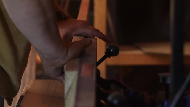man sawing wood on a jointer in a home workshop