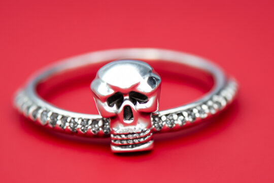 Ring with skull and red. Jewelry diamond gold concept. Ring with skull and red ation on a silver. Ring with skull and silver ation lifestyle on a red.