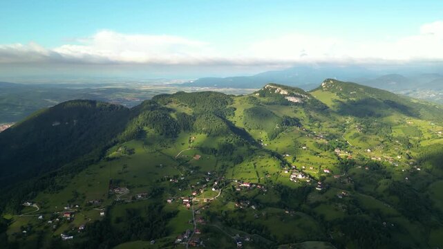 High angle flyover footage over the magnificent picturesque village of Magura in Brasov region of the Romanian Carpati mountains. Drone shot of the gem of romanian tourism on a green summer day.

