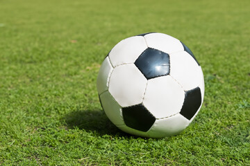 Fototapeta premium Man is playing soccer the greens on lawn. goal field team concept. man is playing soccer on green lawn and he is sporting a ball on it. a man is playing soccer on a green lawn with a ball white in.