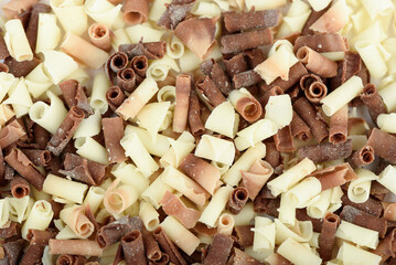 Full frame of white and dark chocolate shavings as a background.