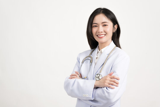 Portrait female doctor wearing medical uniform and stethoscope at hospital.Beautiful smiling young asian woman doctor isolated on white background.Doctor arms crossed wear white coat and stethoscope. - Powered by Adobe