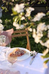 Stylish table setting with beautiful spring flowers in garden