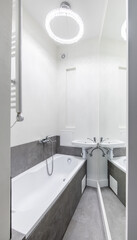 Home Bathroom Interior. Bath and Sink. Mirror, Heater, LED Light. White Color Walls aad Ceiling.