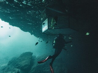 A woman scuba diver enters the airbell in underwater cavern at Blue Grotto, Florida