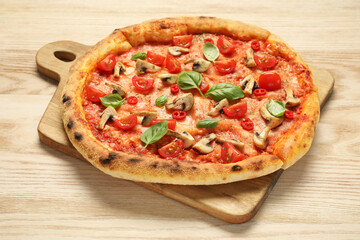 Delicious pizza with tomatoes, mushrooms and basil on wooden table, closeup