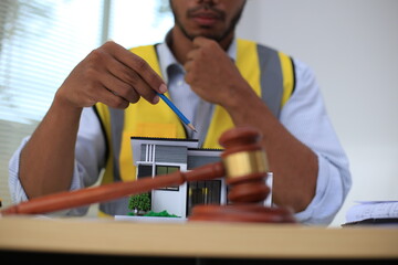 Asian architect and designer using blueprints and laptop to draw building structure in office. Construction concept, Engineering concept, Building plan, Building permit, Home architecture, Engineering