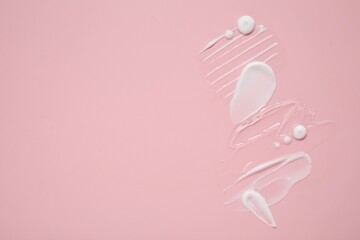 Face cream and gel on pink background, top view. Space for text