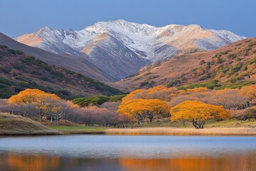 Obraz premium Majestic autumn landscape with colorful trees and snow-capped mountains