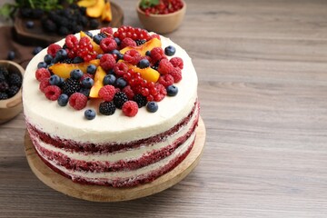 Tasty sponge cake with different fruits on wooden table, space for text