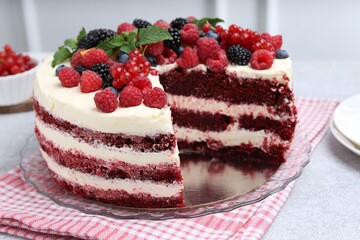 Tasty sponge cake with different berries on light grey table