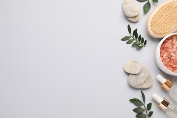 Different cosmetic products and leaves on light grey background, flat lay. Space for text