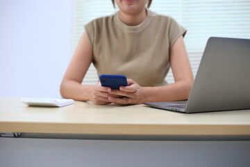 Successful Asian businesswoman sitting at desk working using laptop computer in office. Business and people concept. Businesswoman using laptop computer and working with documents.