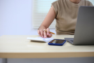 Fototapeta premium Successful Asian businesswoman sitting at desk working using laptop computer in office. Business and people concept. Businesswoman using laptop computer and working with documents.