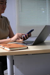 Fototapeta premium Successful Asian businesswoman sitting at desk working using laptop computer in office. Business and people concept. Businesswoman using laptop computer and working with documents.