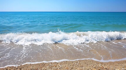 Gentle Waves Lapping on the Sandy Shore Under Clear Blue Sky at Midday