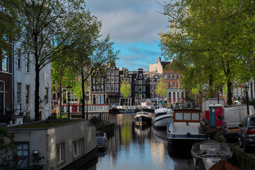 Obraz premium Facades of old historic Houses and trees over canal water, Amsterdam, Netherlands