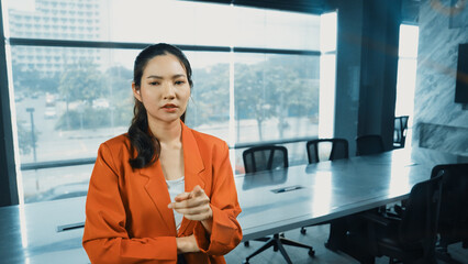 Professional young beautiful businesswoman thinking while standing at glass board with colorful...