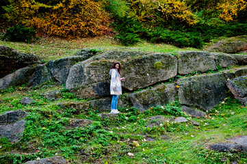 Girl in autumn style. Girl on rocky landscape full length. Autumn girl in park. Central park landscape in fall season. Fall woman in park. Autumn woman outdoor. Woman posing in fall nature