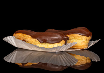 Two eclairs with cream, macro, isolated on a black background.