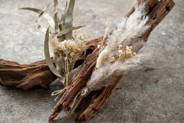 Beautiful dried flower bouquet on driftwood.
Stylish still life image.