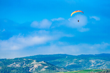 Paraglider flying over spanish nature landscape in Andalucia.