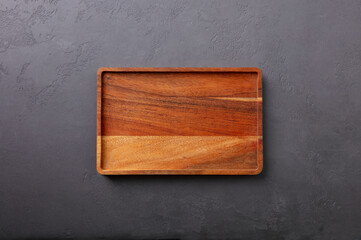Wooden tray, cutting board. Dark background. Frame copy space. Top view.