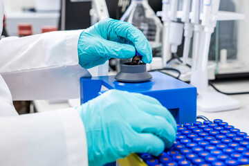 Close up of a chemist shaking samples using a vortex mixer before HPLC analysis in the laboratory 