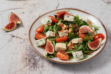 salad with figs, rucola and walnuts. salad with rucola. salad on a light background