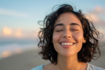 A woman with curly hair is smiling and looking at the camera. She has a bright and happy expression on her face