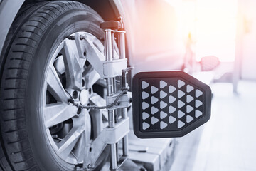 Vehicle inside garage workshop for auto camber fixing work. Closeup car wheel alignment on stand...