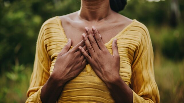 A person with their hands over their heart, expressing gratitude or love