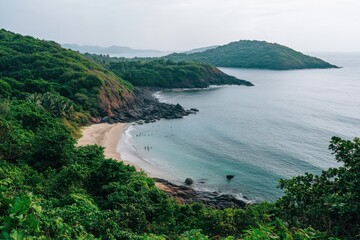 view from the top of a rocky beach, the sea is calm and flat with some small waves