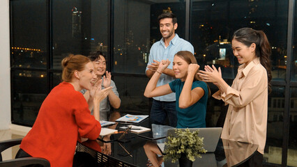 Businesspeople putting hands together and clapping hands to celebrate successful project at modern office with night city view. Group of manager with stacks of hands. Teamwork, trust. Tracery