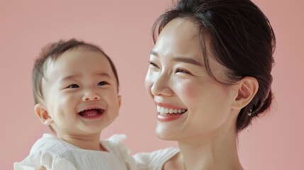 Heartwarming bond between an Asian mother and her smiling baby, beautifully showcased in a studio portrait.