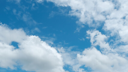 Fototapeta premium Bright blue sky with scattered white clouds on a sunny day, perfect for nature and weather-related themes.