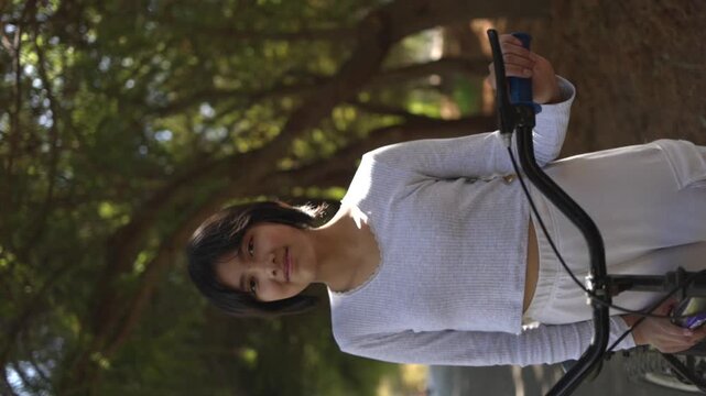 Portrait of a mexican teenager posing with a bicycle outdoors vertical video