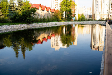 Fototapeta premium The crystalclear, shimmering water beautifully reflects the nearby buildings, creating a truly picturesque scene that harmoniously blends various urban and natural elements