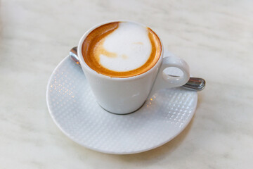 Cup of hot cappuccino coffee on a table