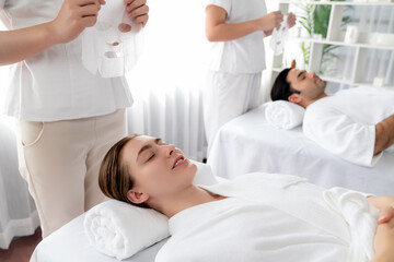 Obraz premium Serene modern daylight ambiance of spa salon, couple customer indulges in rejuvenating with facial skincare mask. Facial skin treatment and beauty cosmetology procedure for face. Quiescent