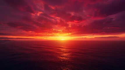 Fototapeta premium Dramatic sunset over the ocean with fiery sky and clouds.