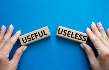 Useful or Useless symbol. Concept word Useful or Useless on wooden blocks. Businessman hand. Beautiful blue background. Business and Useful or Useless concept. Copy space