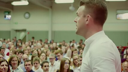 A dynamic speaker captivates an eager crowd, sharing motivational insights that resonate deeply with those in attendance