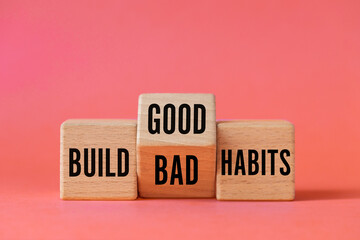 Symbol of building good or bad habits. Turned wooden block and changing the word Build Bad Habits...
